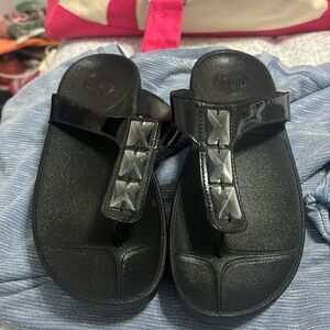Black patent leather fit-flops with geometric accents